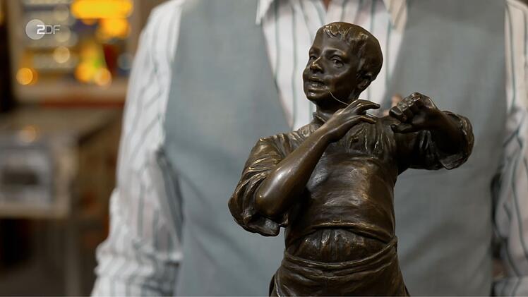 "Der will sich einen Zahn ziehen", vermutete Lichter. Die H&auml;ndler fragten sich, ob der Junge angelte, Fl&ouml;te spielte oder Zahnseide benutzte. Silvio erkl&auml;rte: Die Bronze-Statuette hie&szlig; "Der Saitenspieler". Friedrich H&auml;usser bezahlte 2.100 Euro - 100 &uuml;ber der Expertise.