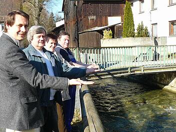 Symbolisch halten Bürgermeister und Anlieger gemeinsam die marode Zufahrtsbrücke über die Zaubach. Sie muss ersetzt werden. Im Bild (von links) Roland Wolfrum, Konrad Bauer, Christine Spindler und Karl-Heinz Kotschenreuther.  Foto: kpw