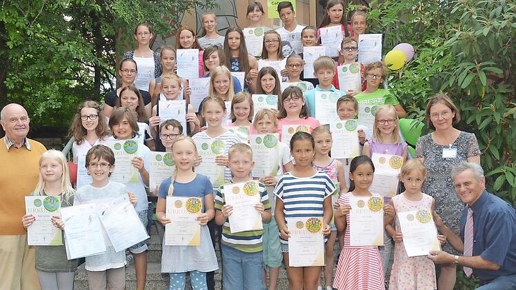 Altlandrat und Bezirksrat Oswald Marr (r.) und der ehemalige Schulleiter Walter Klose (l.) sowie die Fachlehrerin Birgit Eichstätter (2. v. r.) überreichten den Nachwuchsmusiker die Urkunden und Anstecknadeln. Foto: eh