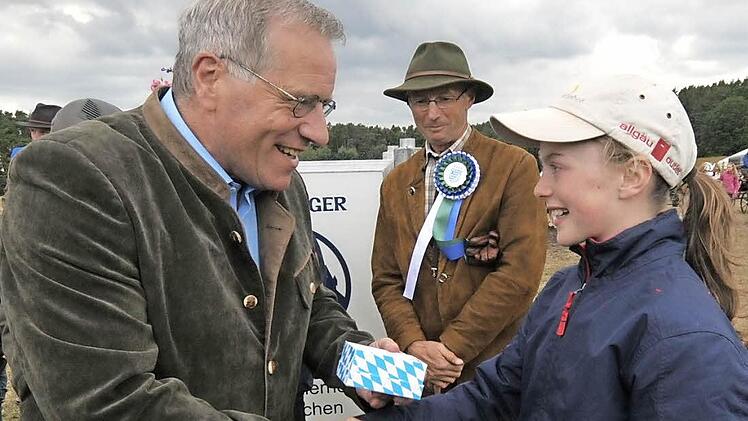 Die zwölfjährige Hannah Rietzler bekommt von Staatsminister Johannes Hintersberger einen bayerischen Löwen aus Porzellan.