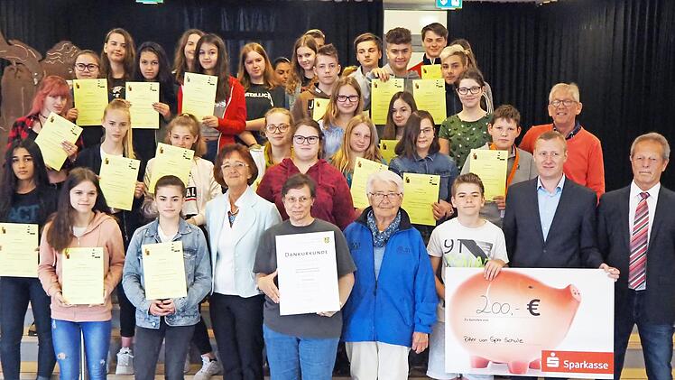 Schulleiter Michael Ulbrich und Lehrerin Susanna Wunner der Ritter-von-Spix-Mittelschule nehmen mit ihren Sch&uuml;lern die Dankesurkunde des Landratsamtes entgegen. Foto: Landratsamt Erlangen-H&ouml;chstadt