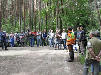 Dominic de Hasque erklärt den Teilnehmern anhand einer Bodenprobe die Baumarteneignung.