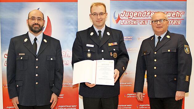 Kreisjugendfeuerwehrwart Kreisbrandmeister Tino Schamberger (links) und Kreisbrandrat Timm Vogler (rechts) überreichten die Ehrennadel der Jugendfeuerwehr Oberfranken an Kreisbrandmeister Tobias Winterbauer (Neuensee, Mitte).
