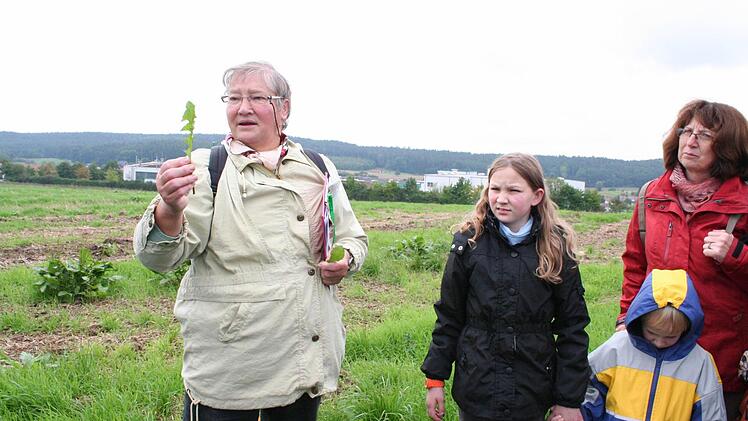 Eines der vielfältigsten Kräuter, den Löwenzahn, erklärt Kräuterführerin Elis Lechner (links). Foto: Evi Seeger