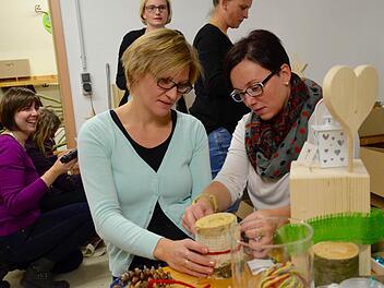 Gemeinsam macht Basteln mehr Spaß: Ramona Schlereth und Caroline Schlereth (von links) sind hier dabei, einen Kerzenständer mit Bändern zu verzieren. Im Hintergrund werkeln weitere Mütter. Foto: Kathrin Kupka-Hahn