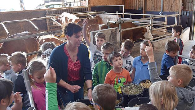 Michaela Ehrlich erkl&auml;rt den Kindern, was auf dem Speiseplan der K&uuml;he steht. Foto: Gabi Arnold