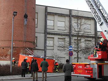 Aufatmen bei Polizei und Rettungskräften: Um 12.55 Uhr klettert der Mann vom Spinnerei-Schlot nach unten. Der verzweifelte Asylbewerber aus Afghanistan macht durch seine einstündige Aktion am Donnerstag darauf aufmerksam, dass er Angst hat, nach Afghanistan abgeschoben und dort getötet zu werden. Foto: Stephan Tiroch