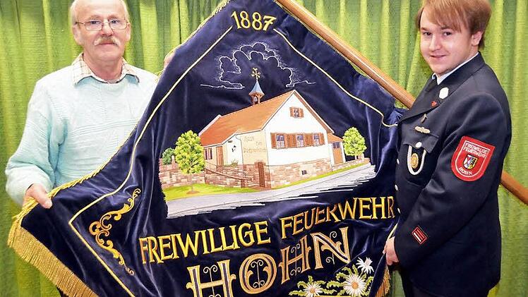 Die Fahne der Feuerwehr Hohn, die Franz Holzheimer und Florian Thoma hier entfaltet haben, ist dringend reparaturbedürftig. Der Feuerwehrverein entschied sich jetzt für eine Sanierung, sucht aber weiter einen stellvertretenden Kommandanten. Foto: Archiv/Peter Rauch