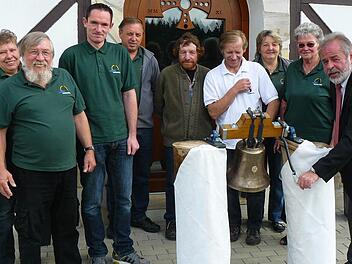 Ein denkwürdiger Moment für das Kapellenbauprojekt Hinterrehberg: Ingrid und Bruno Tittel (links) haben die Glocke in Passau abgeholt, und Bürgermeister Norbert Volk (rechts) blieb es vorbehalten, das neue Stück zum ersten Male erklingen zu lassen. Mit im Bild (hinten von rechts) Monika Turbanisch, Loni Sachs, Harald Wirth, Roland Stäsche, Lothar Kemnitzer und Michael Kühnel.  Fotos: Klaus-Peter Wulf