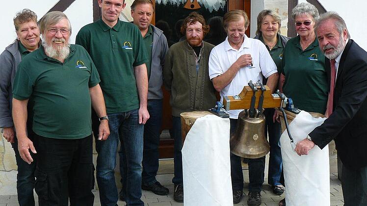 Ein denkwürdiger Moment für das Kapellenbauprojekt Hinterrehberg: Ingrid und Bruno Tittel (links) haben die Glocke in Passau abgeholt, und Bürgermeister Norbert Volk (rechts) blieb es vorbehalten, das neue Stück zum ersten Male erklingen zu lassen. Mit im Bild (hinten von rechts) Monika Turbanisch, Loni Sachs, Harald Wirth, Roland Stäsche, Lothar Kemnitzer und Michael Kühnel.  Fotos: Klaus-Peter Wulf