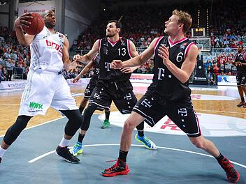 Sharrod Ford (links) narrt die Bonner Tony Gaffney (Mitte) und Benas Veikalas (rechts). Die Brose Baskets gewinnen gegen die Telekom Baskets mit 88:68. Foto: David Ebener/dpa
