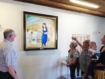 George Charbonnier erklärt Pater Markus Reis (links) seine Interpretation der  österlichen Szene mit seiner Figur der Maria Magdalena im Zentrum des Bildes. Auch seine Frau Christiane und Elisabeth Mehler mit Charbonniers Enkel Arthur  auf dem Arm hören ihm zu.Foto: Heike Beudert