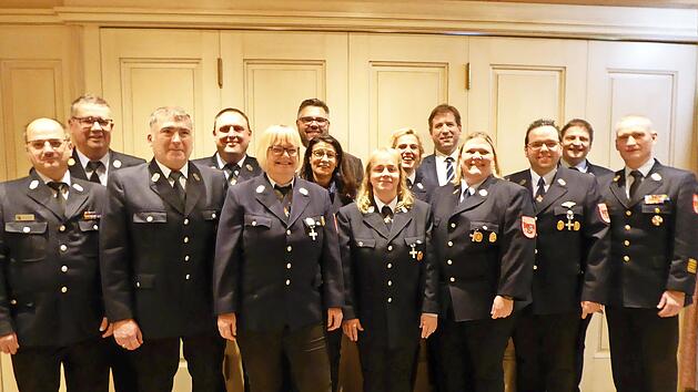 Die sieben geehrten Aktiven, Landrat Hermann Ulm (5. v. r,), Kreisbrandrat Oliver Flake (r.), B&uuml;rgermeister Marco Friepes (6. v. l. hinten) und die gesamte Feuerwehrf&uuml;hrung freuen sich &uuml;ber die Auszeichnungen.