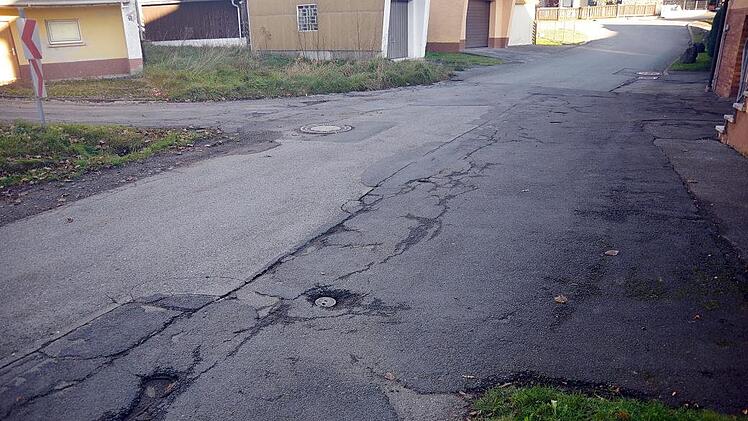 Die ie Mitglieder schauten die Straßenschäden am Dorfplatz an.