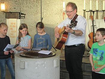 Kommunionkinder aus Pfaffenhausen singen zum Gitarrenspiel von Pfarrer Thomas Eschenbacher.Foto: Winfried Ehling