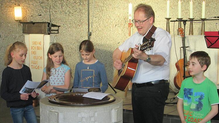Kommunionkinder aus Pfaffenhausen singen zum Gitarrenspiel von Pfarrer Thomas Eschenbacher.Foto: Winfried Ehling
