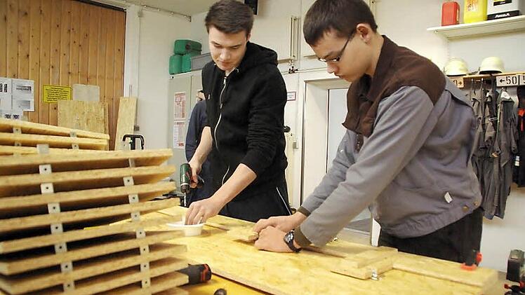 Andreas und Björn fertigen Seitenwände vor. Dazu benutzen sie selbstgefertigte Schablonen fürs exakte Anschrauben. Foto: Elisabeth Assmann