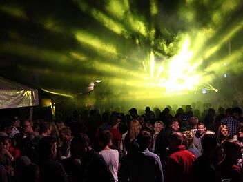 Stadtfest Bad Brückenau 2015: Vor der Jugendbühne in der Altstadt drängen sich die Leute, während eine Laser-Show den Nachthimmel mit bunten Farben beleuchtet. Foto: Friedemann Müller