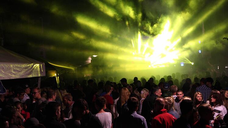 Stadtfest Bad Brückenau 2015: Vor der Jugendbühne in der Altstadt drängen sich die Leute, während eine Laser-Show den Nachthimmel mit bunten Farben beleuchtet. Foto: Friedemann Müller