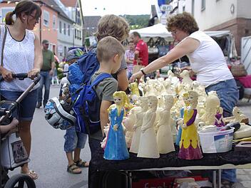 Lydia Baier (r.) zeigt jungen Interessierten, wie ihre selbst gegossenen Figuren farbig gestaltet werden können.  Fotos: Wifnried Ehling