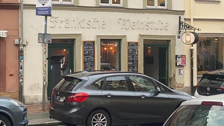 Fassade einer traditionellen Bar in Bamberg, &bdquo;Fr&auml;nkische Weinstube&ldquo;, mit geparkten Autos davor. Die Bar schlie&szlig;t, plant jedoch ein neues Konzept f&uuml;r den Standort.