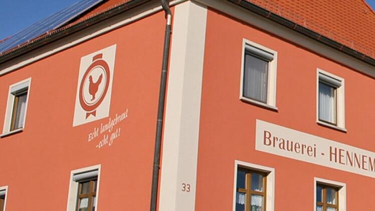 Das Bild zeigt ein rotes Geb&auml;ude mit dem Schriftzug "Brauerei HENNEMANN". Es geh&ouml;rt zur Familienbrauerei Hennemann in Sambach, die bald schlie&szlig;en muss.