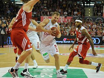 ohn Bryant (l) und Malcolm Delaney (r) von München sowie Anton Gavel von Bamberg kämpfen um den Ball. Fotos: Andreas Gebert/dpa