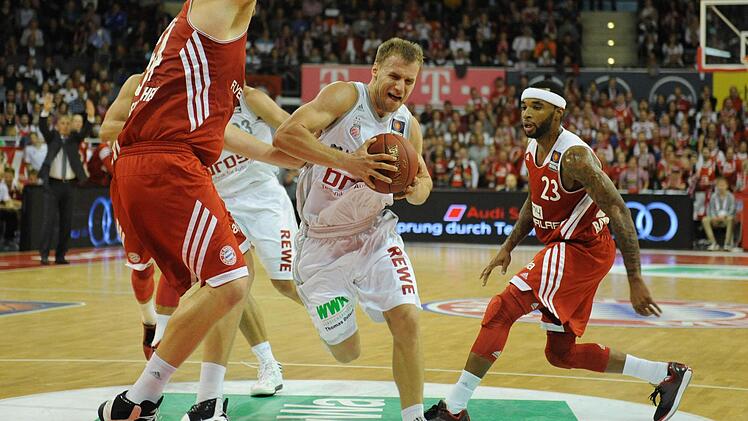 ohn Bryant (l) und Malcolm Delaney (r) von München sowie Anton Gavel von Bamberg kämpfen um den Ball. Fotos: Andreas Gebert/dpa