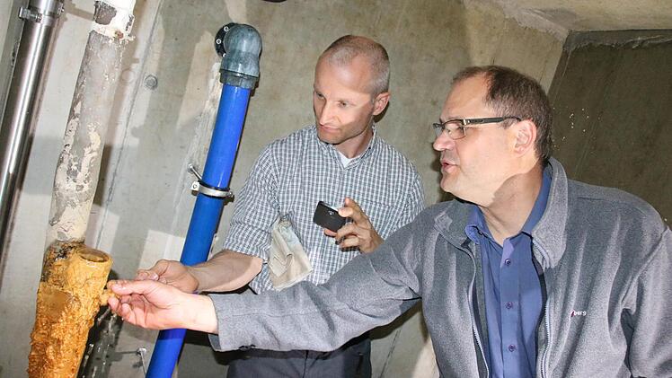 Jirka Skrbek (von links) vom Ingenieurbüro "Schüßler-Plan" und Professor Traugott Scheytt von der TU Berlin begutachten im Schacht vor dem Neuen Rathaus die Ablagerung am Überlauf der Grundwasser-Regulierung. Foto: Ralf Ruppert