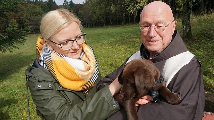 Die acht Wochen alte Frida, ein  Golden Retriever-Labrador mix lies sich  von Pater Georg gerne auf den Arm nehmen. Teresa Kopietz aus Hohenroth  ist die Eigentümerin. Foto: Marion Eckert