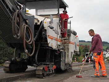 Erwin Hahn steuert die Asphaltfräse, während Florian Schuhmann den Besen schwingt. Fotos: Ulrike Müller