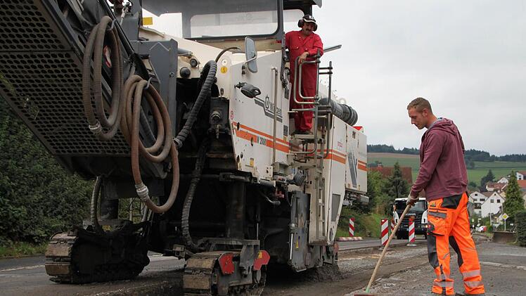 Erwin Hahn steuert die Asphaltfräse, während Florian Schuhmann den Besen schwingt. Fotos: Ulrike Müller