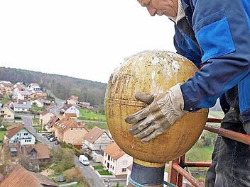 Otto Wilm nimmt die Kirchturmkugel ab. Foto: Roland Bötsch