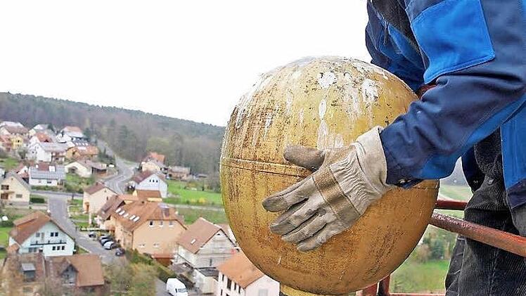 Otto Wilm nimmt die Kirchturmkugel ab. Foto: Roland Bötsch