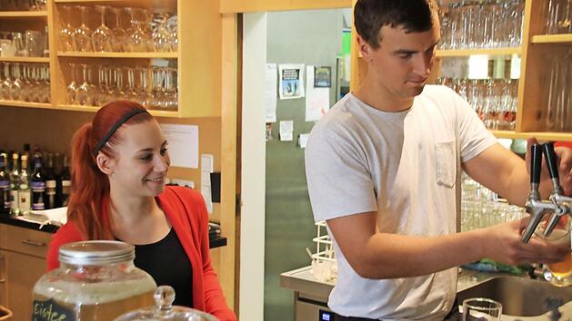 Sandro Wegmann, Held der Ferienarbeit: Servicekraft Larissa Maibaum. zeigt ihm, wie Zapfen funktioniert.  Fotos: Ursula Fellenstein-B&uuml;ttner