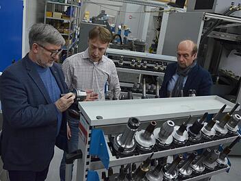 Landrat Michael Busch (links) und Wirtschaftsförderer Martin Schmitz (rechts) lassen sich von Wolfgang Stammberger zeigen, was in seinem Unternehmen hergestellt wird. Foto: Rainer Lutz