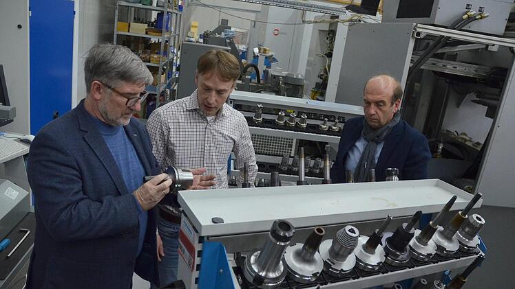 Landrat Michael Busch (links) und Wirtschaftsförderer Martin Schmitz (rechts) lassen sich von Wolfgang Stammberger zeigen, was in seinem Unternehmen hergestellt wird. Foto: Rainer Lutz