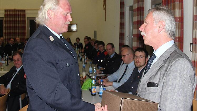 Bürgermeister Ernst Stross (rechts) verabschiedet Kommandant Winfried Kleinhenz mit Dankesworten und einem Präsent.
