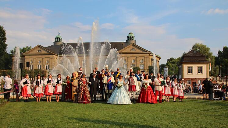 Die historischen Persönlichkeiten stellen sich zum Gruppenbild im Rosengarten auf.