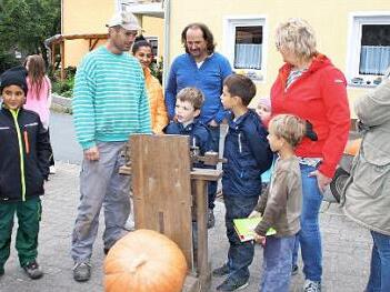 Spannung pur: Der Siegerk&uuml;rbis liegt auf der Waage. Unser Bild zeigt (von links) Martin Eltschka, Jenny und Robert Kleinhenz, Ingrid Markert, Susanne Viernek&auml;s und die Kinder Finn Pfister, Emanuel Kleinhenz, Jonas und Moritz Viernek&auml;s und Ben Hildebrand.  Foto: Kleinhenz