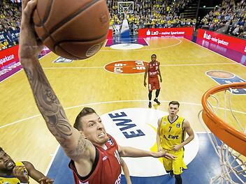 Daniel Theis schließt per Dunking ab. Die Oldenburger Frantz Massenat (l.) und Jan Niklas Wimberg befinden sich in der Zuschauerrolle.  Foto: Ulf Duda