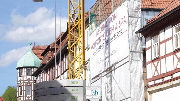 Eine Plane deckt das Gebäude ab, der Kran ist davor auf der Straße platziert. Foto: Marco Meißner