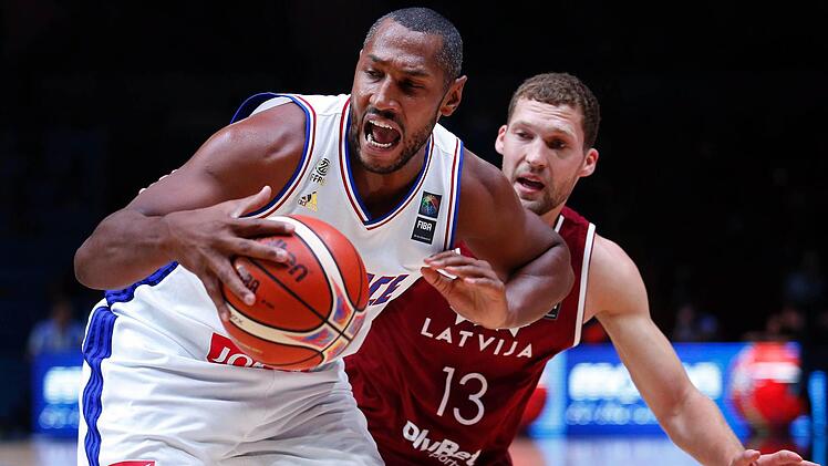 Frankreichs NBA-Veteran Boris Diaw behauptet den Ball gegen den in Bamberg spielenden Letten Janis Strelnieks. Foto: Sebastian Nogier/dpa
