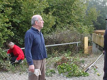 Die Hecken rund um das Hallenbad hatten bereits den Parkplatz erobert. Wolfgang Blümlein (rechts) und Rainer Kirch sowie Harry Koch (im Hintergrund) gehörten zu den Helfern, die auf dem städtischen  Gelände eine Säuberungsaktion vornahmen. Foto: Heike Beudert
