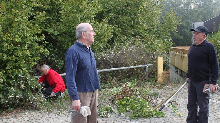 Die Hecken rund um das Hallenbad hatten bereits den Parkplatz erobert. Wolfgang Blümlein (rechts) und Rainer Kirch sowie Harry Koch (im Hintergrund) gehörten zu den Helfern, die auf dem städtischen  Gelände eine Säuberungsaktion vornahmen. Foto: Heike Beudert
