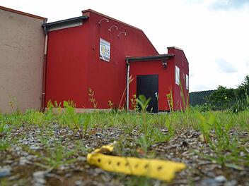 Achtlos weggeworfene gelbe Armbänder erinnern noch daran, dass hier an der Zahlbacher Disco vor wenigen Wochen noch kräftig getanzt und Party gefeiert wurde. Nun erobert das Unkraut den Eingang der mittlerweile geschlossenen Disco.  Foto: Kathrin Kupka-Hahn
