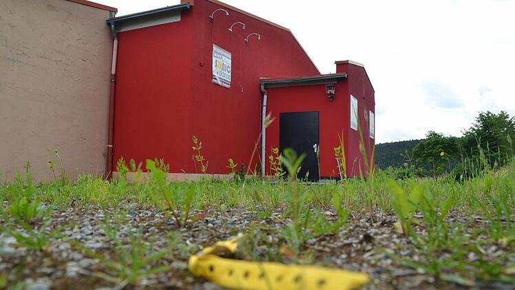 Achtlos weggeworfene gelbe Armbänder erinnern noch daran, dass hier an der Zahlbacher Disco vor wenigen Wochen noch kräftig getanzt und Party gefeiert wurde. Nun erobert das Unkraut den Eingang der mittlerweile geschlossenen Disco.  Foto: Kathrin Kupka-Hahn
