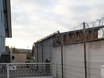 Über die Mauer des Nachbarn hat eine Reckendorferin Stacheldraht gezogen. Direkt an der Wand hinter dem Tor, hat sie auch ein Gewehr zur Abschreckung platziert.  Foto: S. Martin