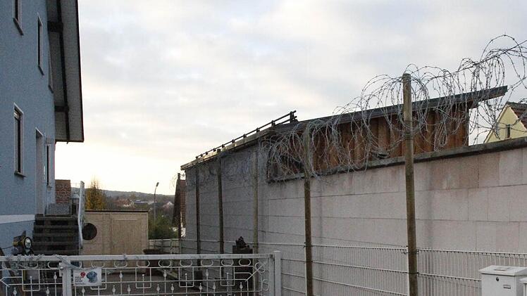 Über die Mauer des Nachbarn hat eine Reckendorferin Stacheldraht gezogen. Direkt an der Wand hinter dem Tor, hat sie auch ein Gewehr zur Abschreckung platziert.  Foto: S. Martin