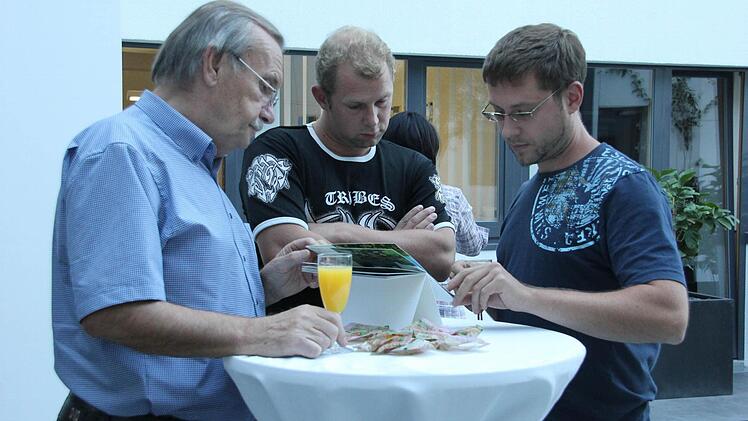 Helmut Büchner, Thomas Schmelzing und Andre Emrich (v.l.) schauen sich den leserkalender an. Foto: Lena Alt